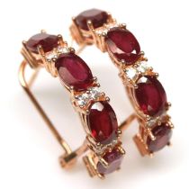 A pair of rose gold on 925 silver hoop earrings set with oval cut rubies and white stones, L. 2.