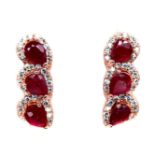 A pair of rose gold on 925 silver earrings set with three oval cut rubies and white stones, L. 1.