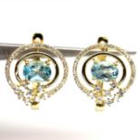 A gold on 925 silver earrings set with oval cut blue topaz and white stones, L. 1.8cm.