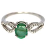 A 925 silver ring set with an oval cut emerald and white stones, (N).