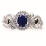 A 925 silver ring set with oval cut sapphire and white stones, (N).