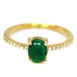 A gold on 925 silver ring set with an oval cut emerald and white stone set shoulders, (N).