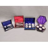 A cased set of six silver plated napkin rings with other cased items.