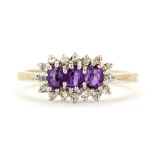 A hallmarked 9ct yellow gold cluster ring set with oval cut amethysts surrounded by diamonds, (P.