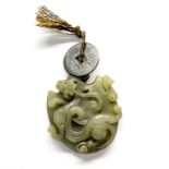 A Chinese carved celadon jade dragon amulet, dia. 5cm.