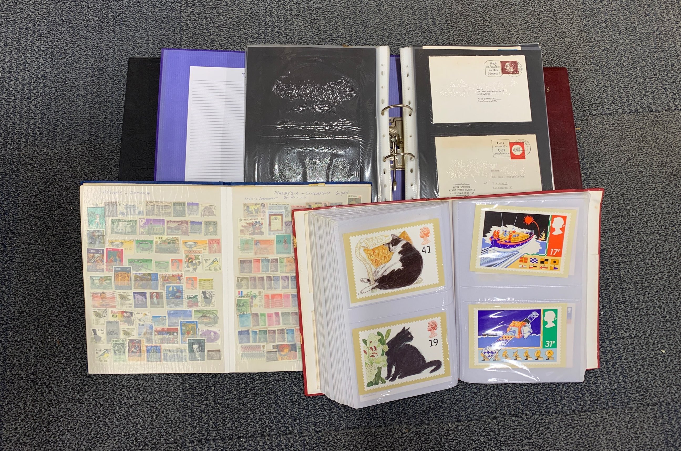 A quantity of first day cover stamp albums and stamp postcards.