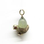 A white metal and polished jade chick pendant (tested silver) with ruby eyes, probably Russian, H.