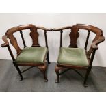A pair of Georgian mahogany corner chairs with upholstered seats and cross banded legs.