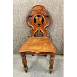 A 19th century carved mahogany hall chair.