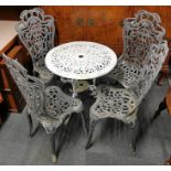 A cast iron garden table with four cast iron chairs, table Dia. 67cm, H. 66cm.