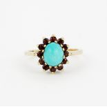 A hallmarked 9ct yellow gold ring set with an oval cabochon turquoise surrounded by round cut