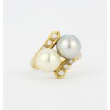 An 18ct yellow gold crossover ring set with two large cultured white and grey pearls and seed