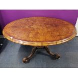 A 19thC burr walnut veneered and carved mahogany tilt top dining table on castors, 145 x 117 x