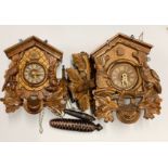 Two wooden black forest wall cuckoo clocks.