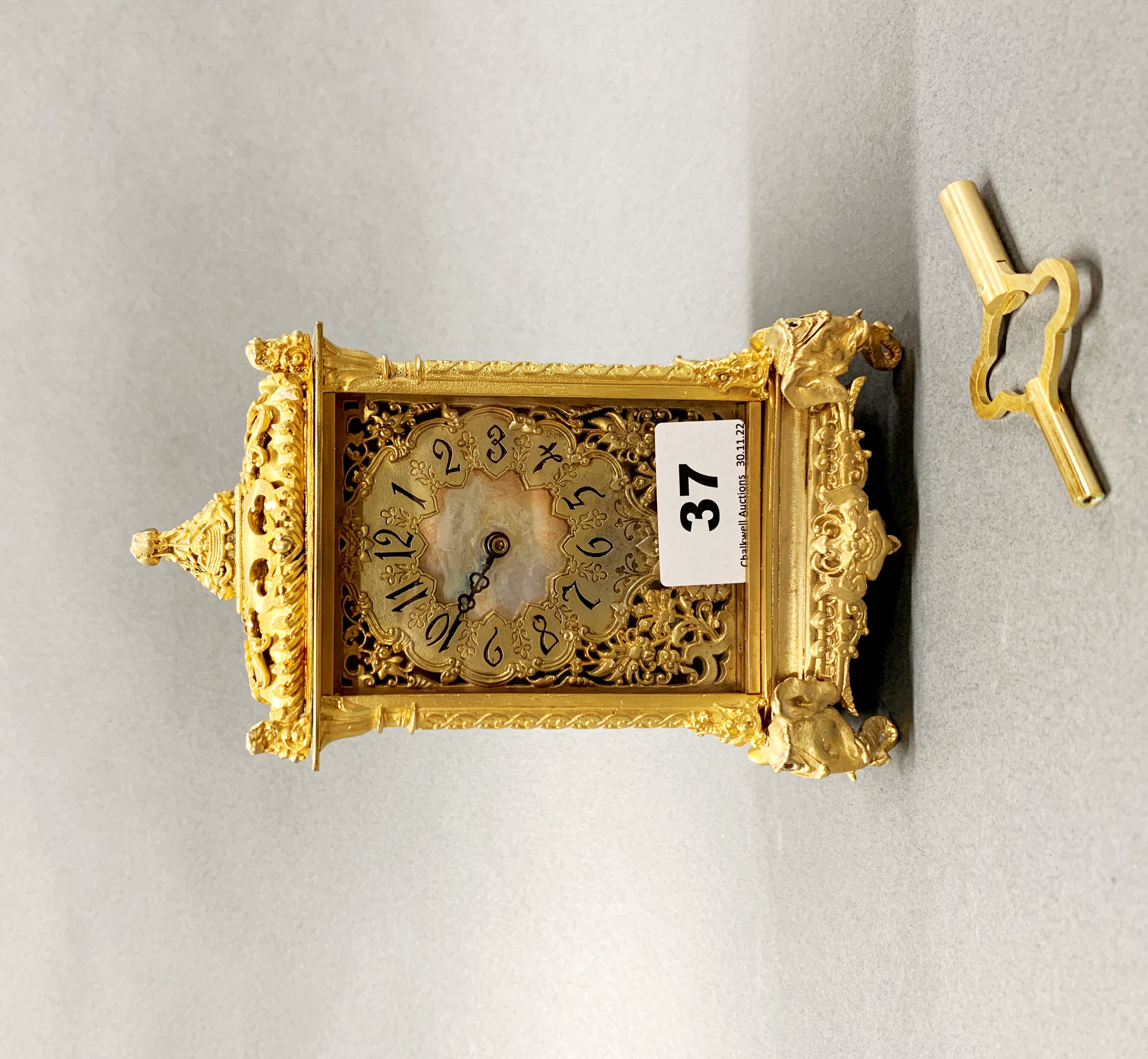 A lovely gilt bronze and mother of pearl dial mantel clock, with elephant head decoration, H. 18cm.