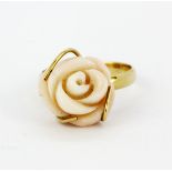 A yellow metal (tested high carat gold) ring set with a carved coral rose, (N).