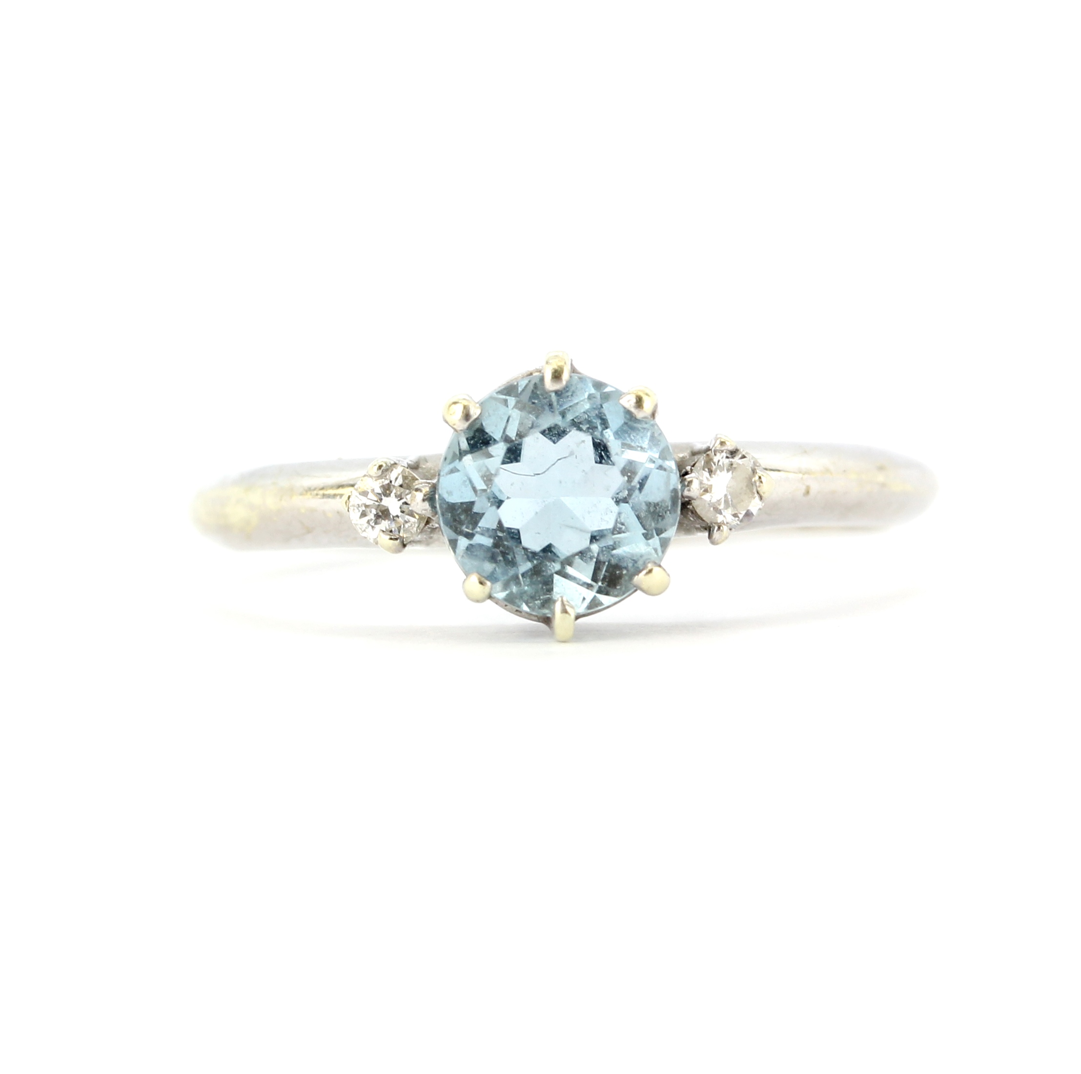 A hallmarked 9ct white gold ring set a round cut aquamarine and diamonds, (N).