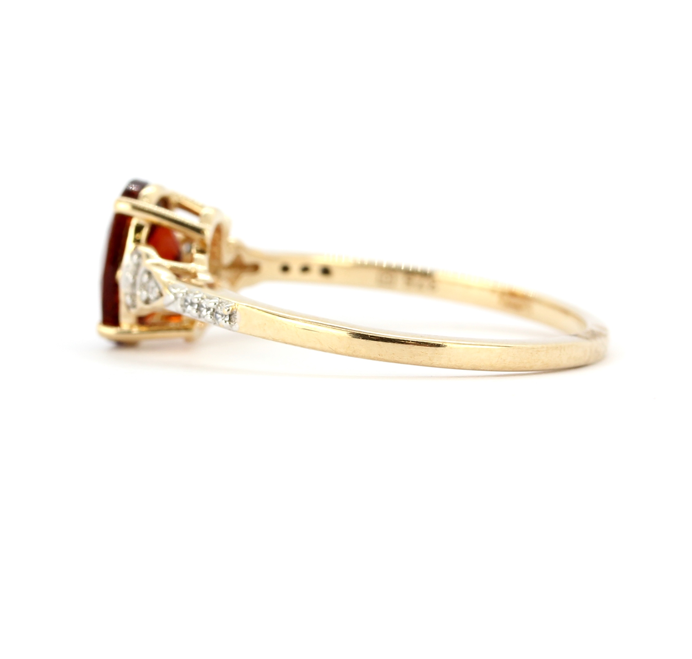 A 9ct yellow gold ring set with an oval cut hessonite garnet and diamond set shoulders, (U). - Image 2 of 2