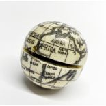 A small engraved and inked globe shaped bone compass, dia. 4cm.