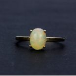 A hallmarked 9ct yellow gold solitaire ring set with an oval cabochon opal, (S).