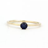 A hallmarked 9ct yellow gold solitaire ring set with a round cut sapphire, (S).