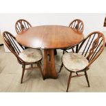 An Ercol oak drop leaf table with four matching Ercol chairs, table W. 106cm, extending to L.