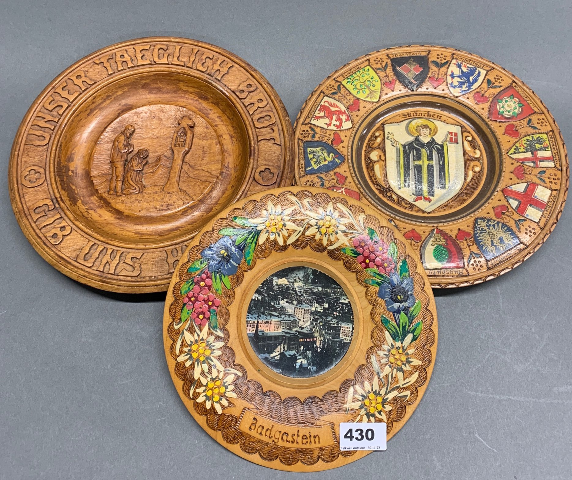 Three mid 20th century carved and painted wooden plates, largest Dia. 28cm.