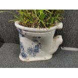 A Victorian ceramic toilet bowl used as a planter.