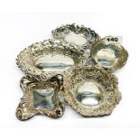 A group of embossed hallmarked silver dishes, widest W. 15cm.