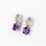 A pair of 18ct white gold drop earrings each set with a cushion cut amethyst and brilliant cut