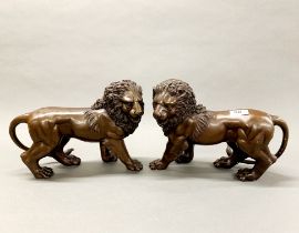 A pair of bronze figures of lions, H 23cm, L. 31cm.