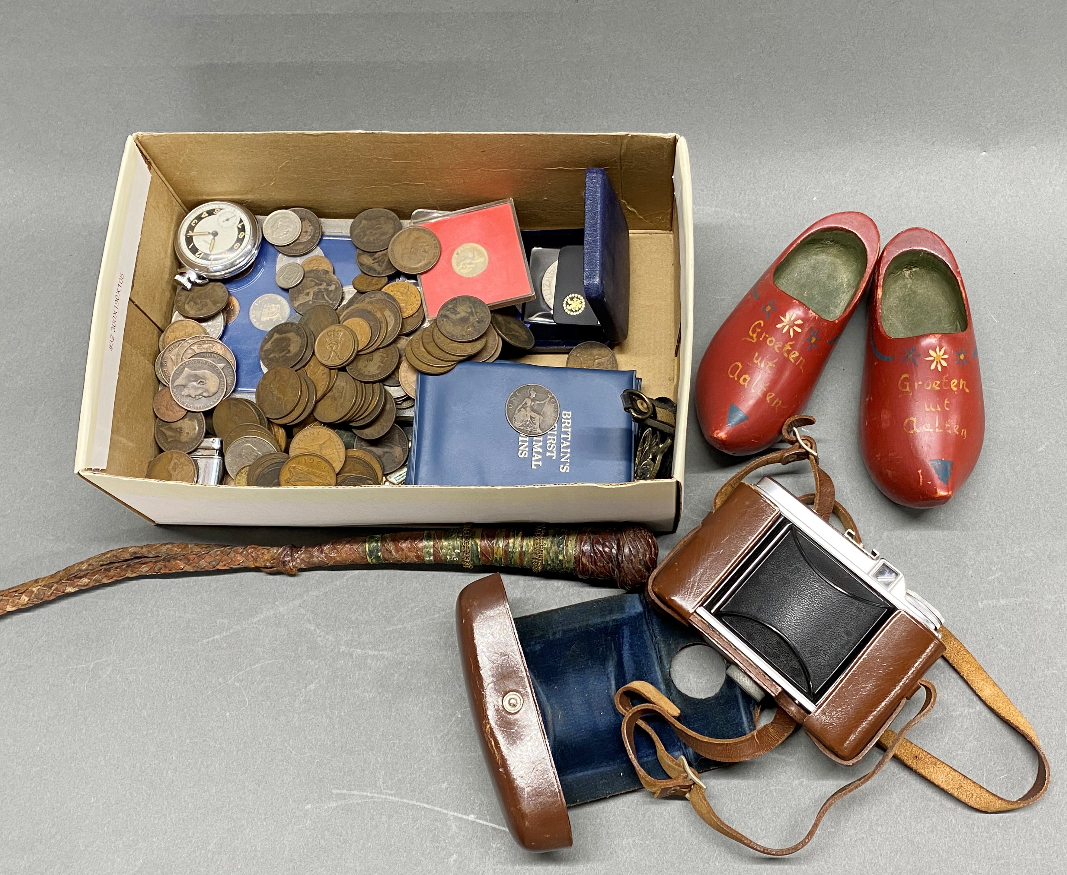 A vintage camera with coins and other items.