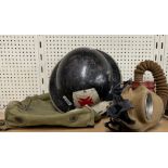 A WWII gas mask, bag and helmet.