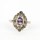 A 925 silver ring set with an oval cut amethyst and marcasite, (Q).