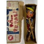 A boxed wooden Pelham puppet of Pinnocchio.