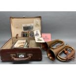 A vintage case containing military hand books, photographs, etc with two bugles.