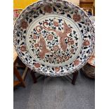 A gigantic Chinese hand painted porcelain charger with purpose made wooden stand, dia. 96cm.