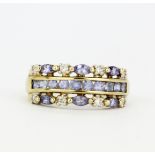 A hallmarked 9ct yellow gold ring set with marquise and round cut tanzanites and diamonds, (P.5).
