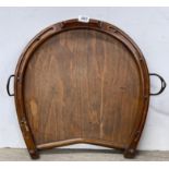 An antique oak horseshoe shaped tray with stirrup shaped handles, 51 x 56cm.