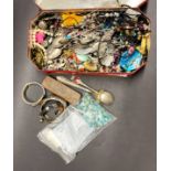 A tin of mixed costume jewellery.