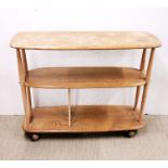 An Ercol light oak three-tier tea trolley on wheels, L. 92cm, H. 71cm. Extensive stains to top.