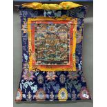 A Tibetan silk mounted hand painted thangka, overall size 50 x 68cm.