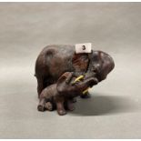 A moulded composition figure of a mother elephant with her calf, H. 15.5cm.