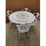 A cast iron white painted garden table with four cast iron white painted chairs, table Dia. 107cm,