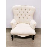 A cream upholstered button backed armchair on castors, H. 88cm.