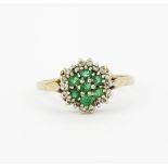 A hallmarked 9ct yellow gold emerald and diamond set cluster ring, (O.5).