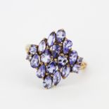 A large 9ct yellow gold ring (stamped 9K) set with pear and marquise cut tanzanites, (O.5).