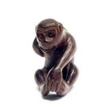 A signed carved fruitwood netsuke of a monkey, H. 5cm.