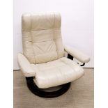 A cream upholstered recllining armchair.