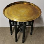 An Eastern brass topped and folding leg coffee table, Dia. 58cm H. 55cm.